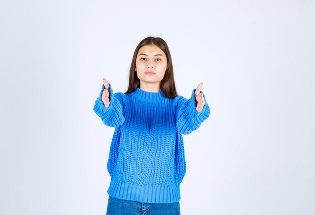 adorabile femmina seria allunga le mani e guarda direttamente la telecamera.