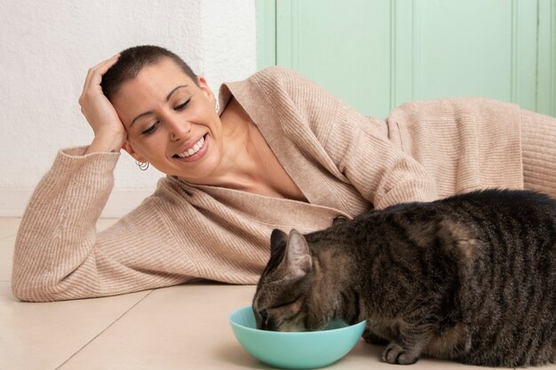 Adorabile gattino che mangia accanto al suo proprietario