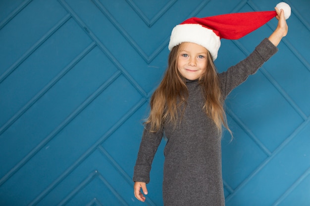 Adorabile ragazza bionda che indossa un cappello di Babbo Natale