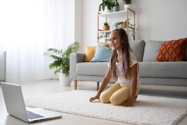 Adorabile ragazza che fa yoga a casa