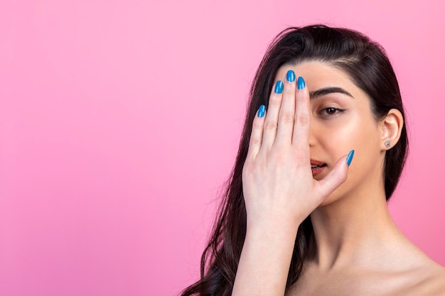 Adorabile ragazza che tiene la mano sull'occhio e guarda la fotocamera Foto di alta qualità