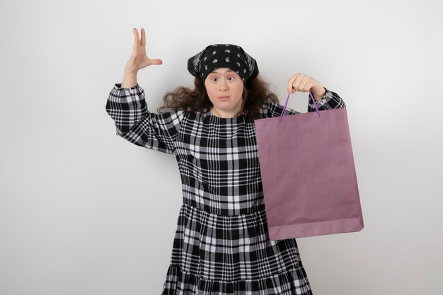 Adorabile ragazza con sindrome di down che tiene la borsa della spesa.