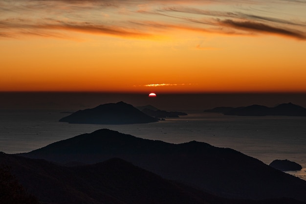 Affacciato su una silhouette di montagne nel mare durante il tramonto