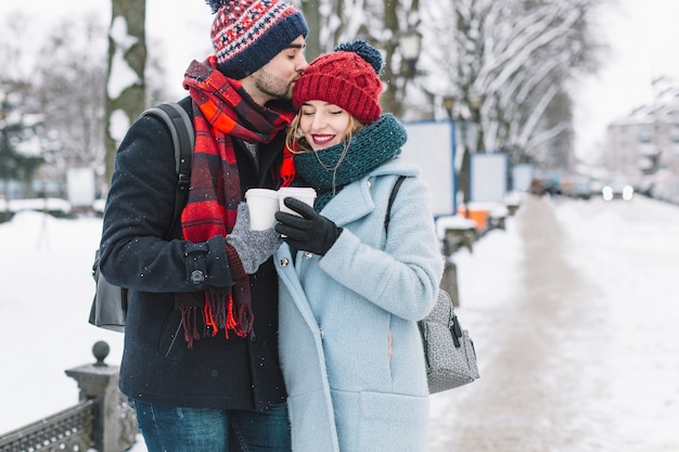 Affascinante giovane coppia con caffè in inverno