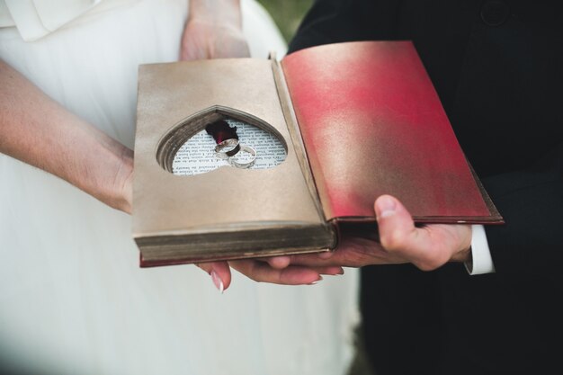 Affascinante libro vintage con cuore fatto a mano in cui giace l'anello. Design elegante.