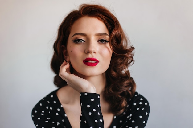 Affascinante modello femminile guardando la fotocamera Sensuale ragazza dai capelli rossi in posa su sfondo grigio