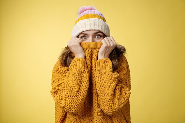 Affascinante ragazza carismatica giocosa che nasconde il viso tira il colletto del maglione naso allarga gli occhi sorpresa felice per...