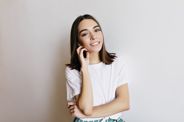 Affascinante ragazza caucasica con i capelli scuri che esprimono emozioni positive. carina signora bruna isolata.