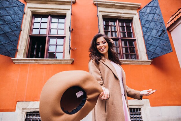 Affascinante signora bruna gira con il suo cappello beige