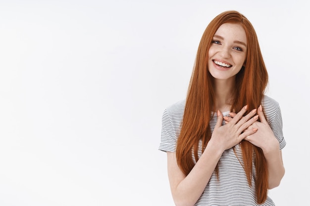 Affascinante vivace tenera femminile giovane rossa ragazza flirtare sembra compiaciuta ridendo con gioia tenere i palmi premuti sul petto gesto commovente toccato, felice sinceramente sorridente