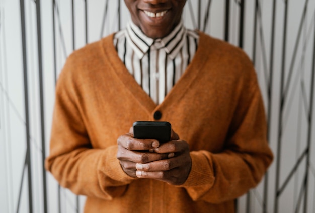 Afroamericano che tiene il suo telefono