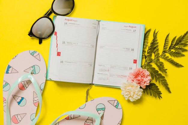 Agenda con flip-flop e occhiali da sole con riflessi