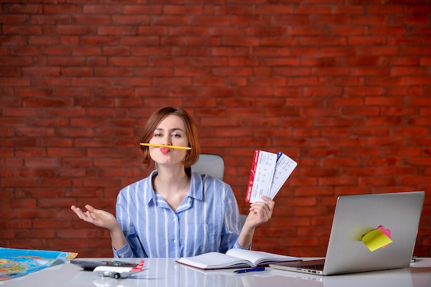 Agente di viaggio vista frontale dietro il suo posto di lavoro con l'assistente del servizio mappa dell'agenzia di biglietti aerei world manager global