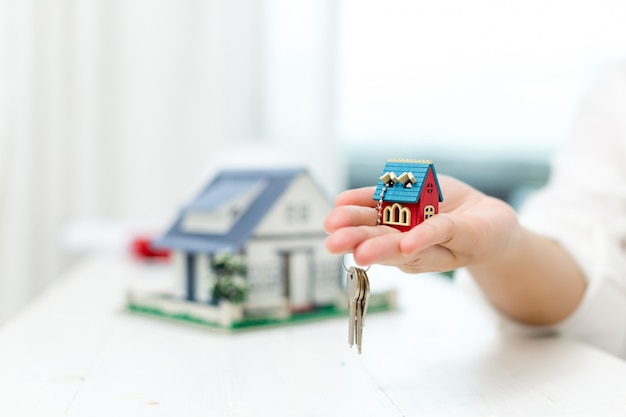 Agente immobiliare con modello di casa e chiavi