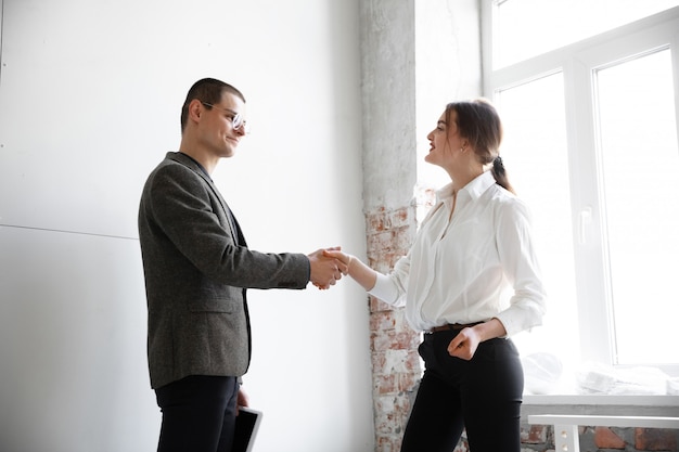 Agente immobiliare femminile che mostra nuova casa ad un giovane dopo una discussione sui programmi della casa, muoversi, nuovo concetto domestico