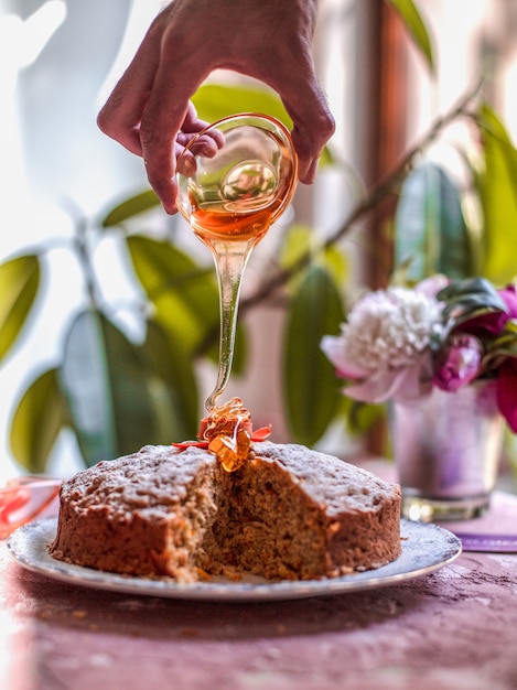 Aggiungendo lo sciroppo d'acero alla torta di carote