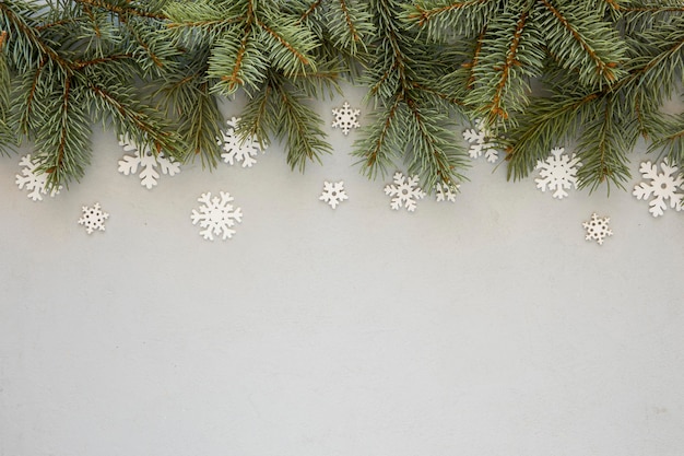 Aghi di pino su sfondo grigio con fiocchi di neve