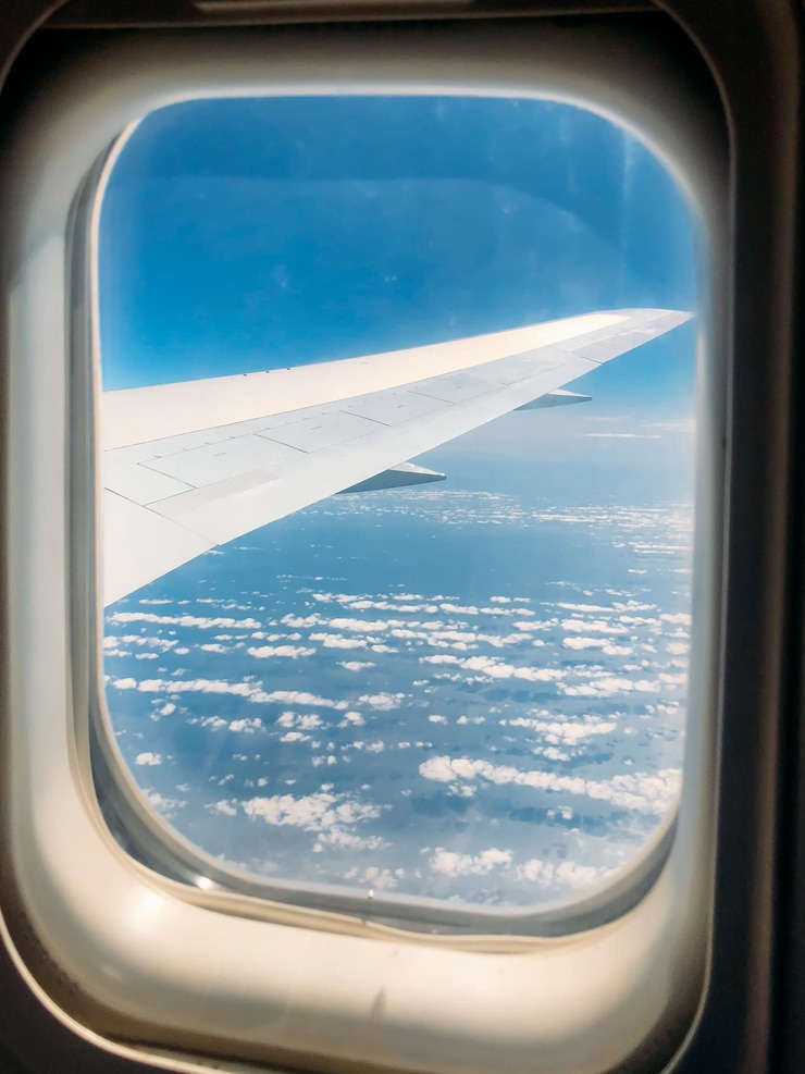 Foto gratuito ala attraverso la finestra dell'aeroplano in un cielo incredibile al tramonto