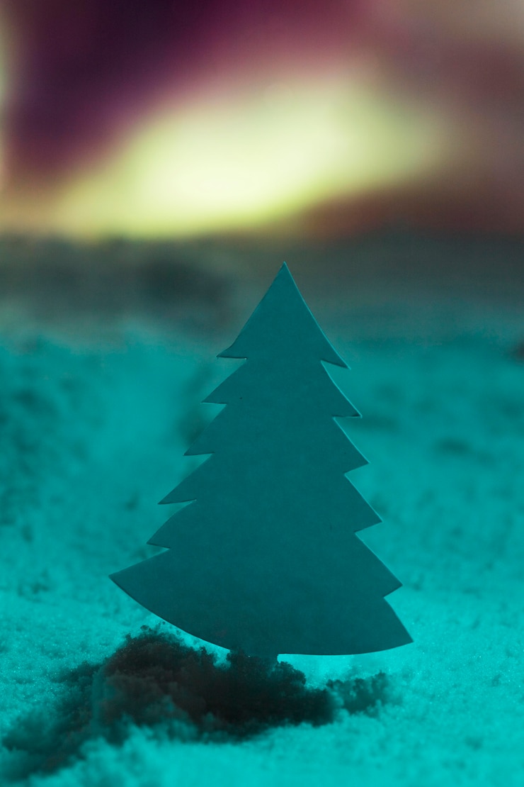 Foto gratuito albero di natale con neve e aurore boreali