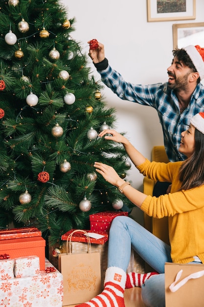 Albero di Natale decorando coppia felice