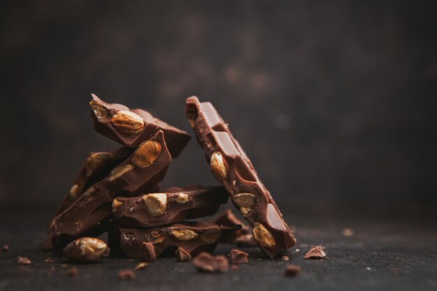 Alcune mandorle con cioccolato su marrone scuro, vista laterale. spazio per il testo