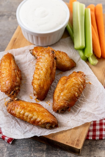 Alette di pollo piccanti di bufalo con salsa di pepe di cayenna su un tavolo di legno