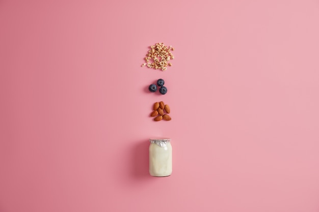 Alimentazione sana, concetto di mangiare pulito. Ingredienti per farina d'avena con mirtilli, mandorle e yogurt. Preparare deliziosi dessert dolci nutrienti a basso contenuto calorico Ora di colazione. Muesli alla frutta.