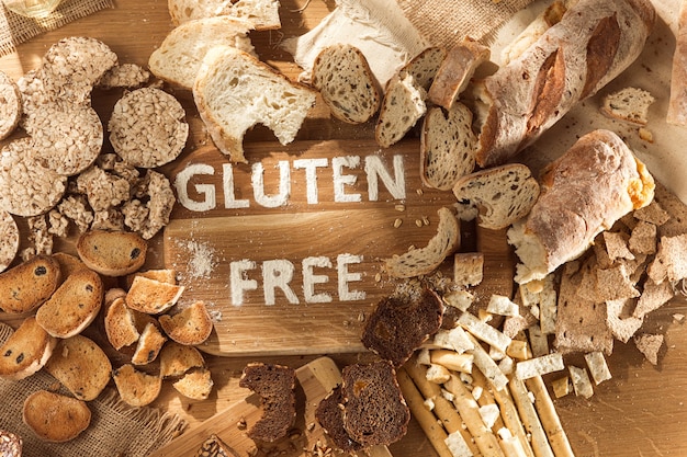 Alimenti senza glutine. Vari pasta, pane e snack su fondo in legno dalla vista dall'alto. Concetto sano e dieta.