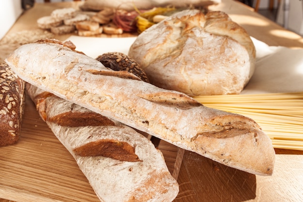 Alimenti senza glutine. Vari pasta, pane e snack su fondo in legno dalla vista dall'alto