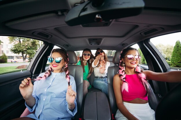 Alla moda, alla moda, le amiche alla moda vanno in macchina ascoltando musica e divertendosi insieme Vanno a fare shopping per la loro città Gli amici riposano insieme e lo shopping è sempre insieme