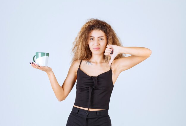 Alla ragazza bionda con una tazza di caffè non piace.