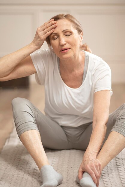 Allegra donna di mezza età che si rilassa dopo aver fatto esercizi di yoga