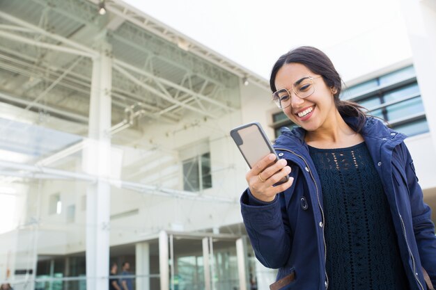 Allegra ragazza ufficio spensierata guardando contenuti divertenti