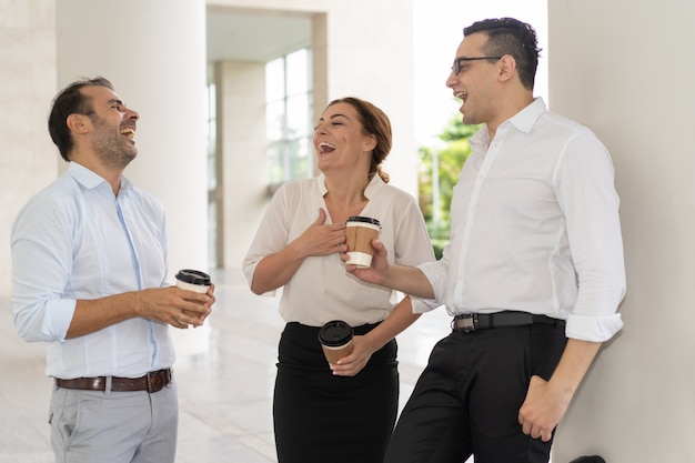 Allegri metà degli adulti colleghi di lavoro ridendo in pausa caffè
