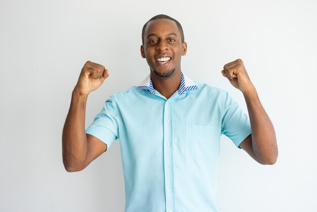 Allegro bel ragazzo africano in camicia a maniche corte facendo sì gesto