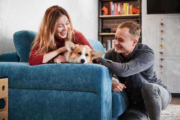 Allegro giovane coppia che accarezza cane carino a casa