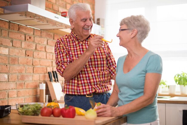 Allegro matrimonio senior che prepara un pasto sano