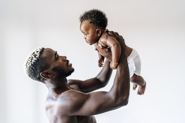 Allegro padre afroamericano che si prende cura e si diverte con il suo bambino