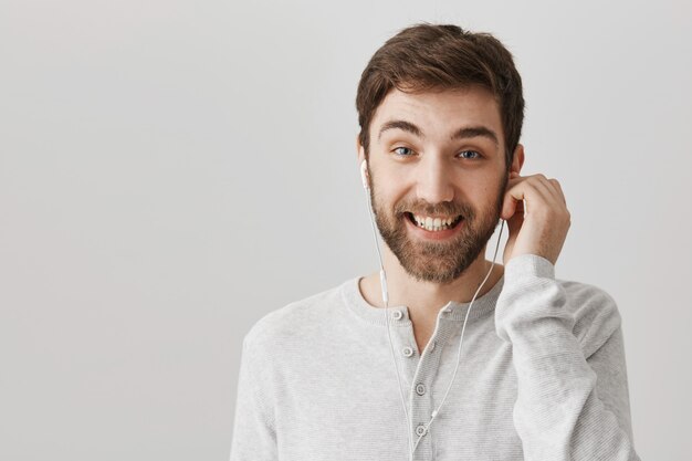 Allegro uomo barbuto ha messo gli auricolari per ascoltare la musica