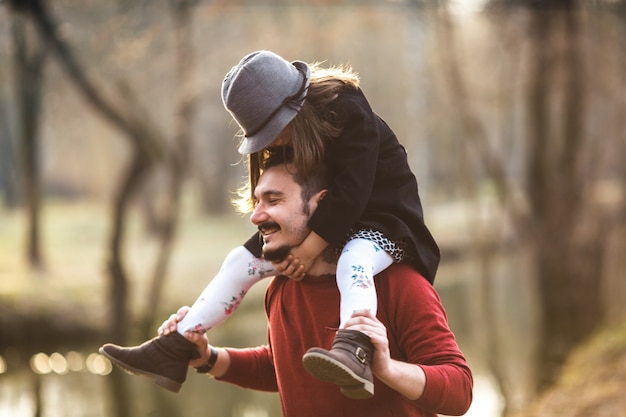 Allegro uomo con la ragazza sulle spalle