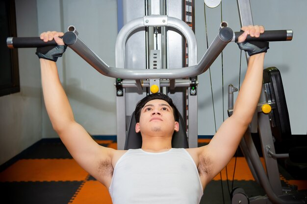 Allenamenti del giovane alla palestra di forma fisica