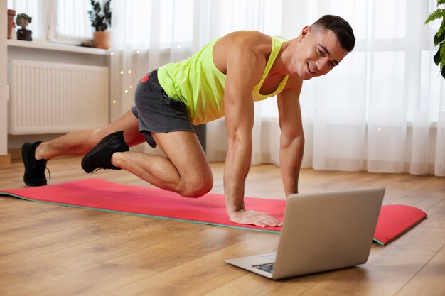 Allenamento completo dell'uomo con il computer portatile