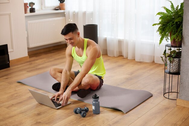 Allenamento completo dell'uomo con il computer portatile