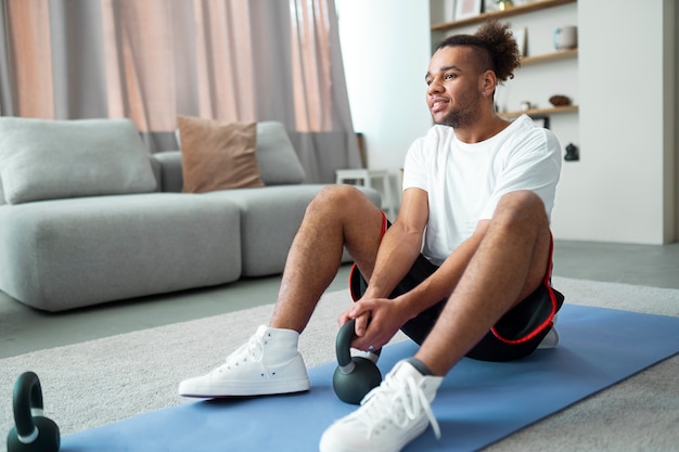 Allenamento completo dell'uomo con kettlebell sul tappetino