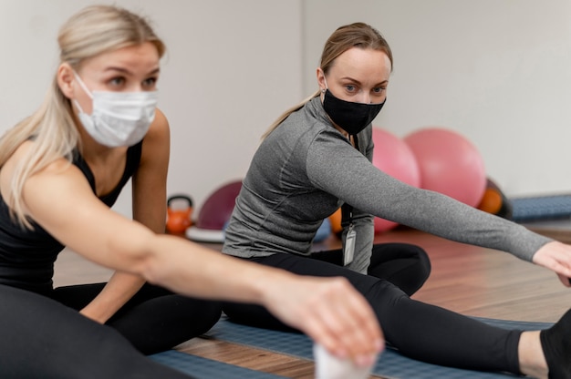 Allenamento con personal trainer che indossa maschere di protezione