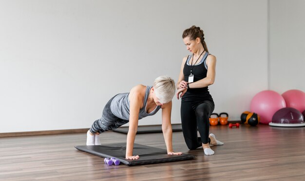 Allenamento con personal trainer sul materassino yoga