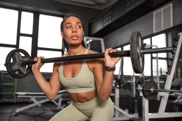 Allenamento donna per sollevamento pesi in palestra