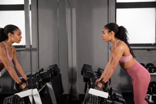 Allenamento donna per sollevamento pesi in palestra