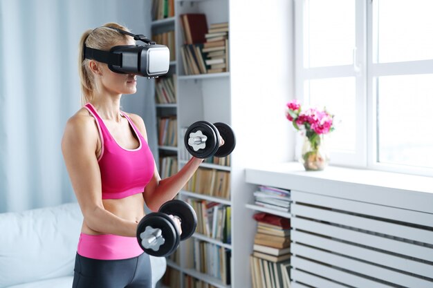 Allenamento fitness donna con manubri e cuffia avricolare vr