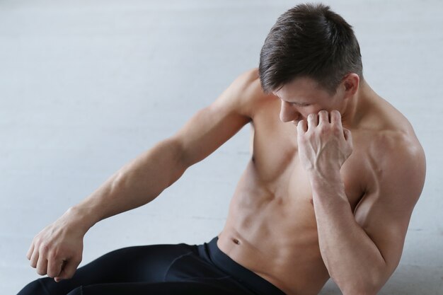 Allenamento fitness uomo. Uomo senza camicia che fa allungando a casa